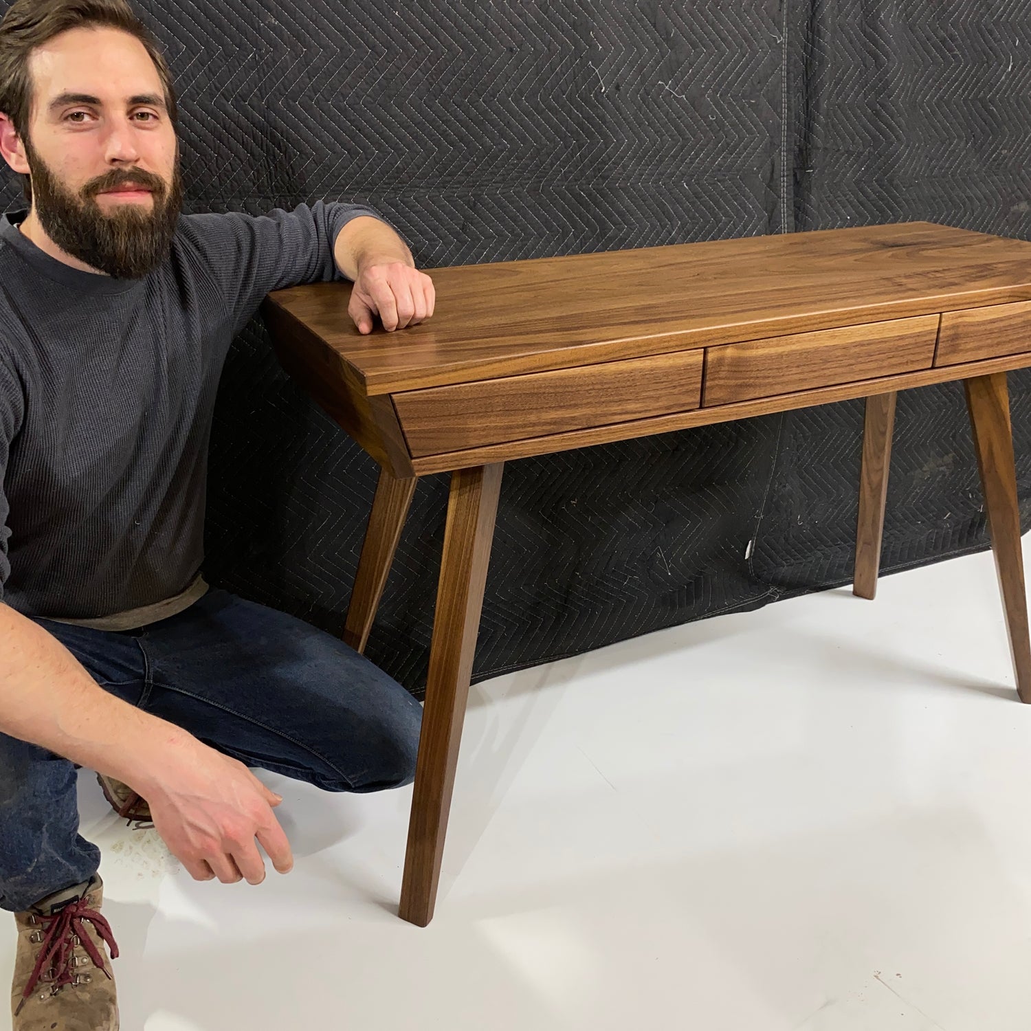 Owner of Columbus Furniture Co. posing with a recently completed walnut writing desk.