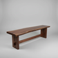 hand crafted walnut bench that features the natural live edges sitting in a photography studio