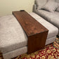 walnut ottoman table fitted over a grey fabric ottoman