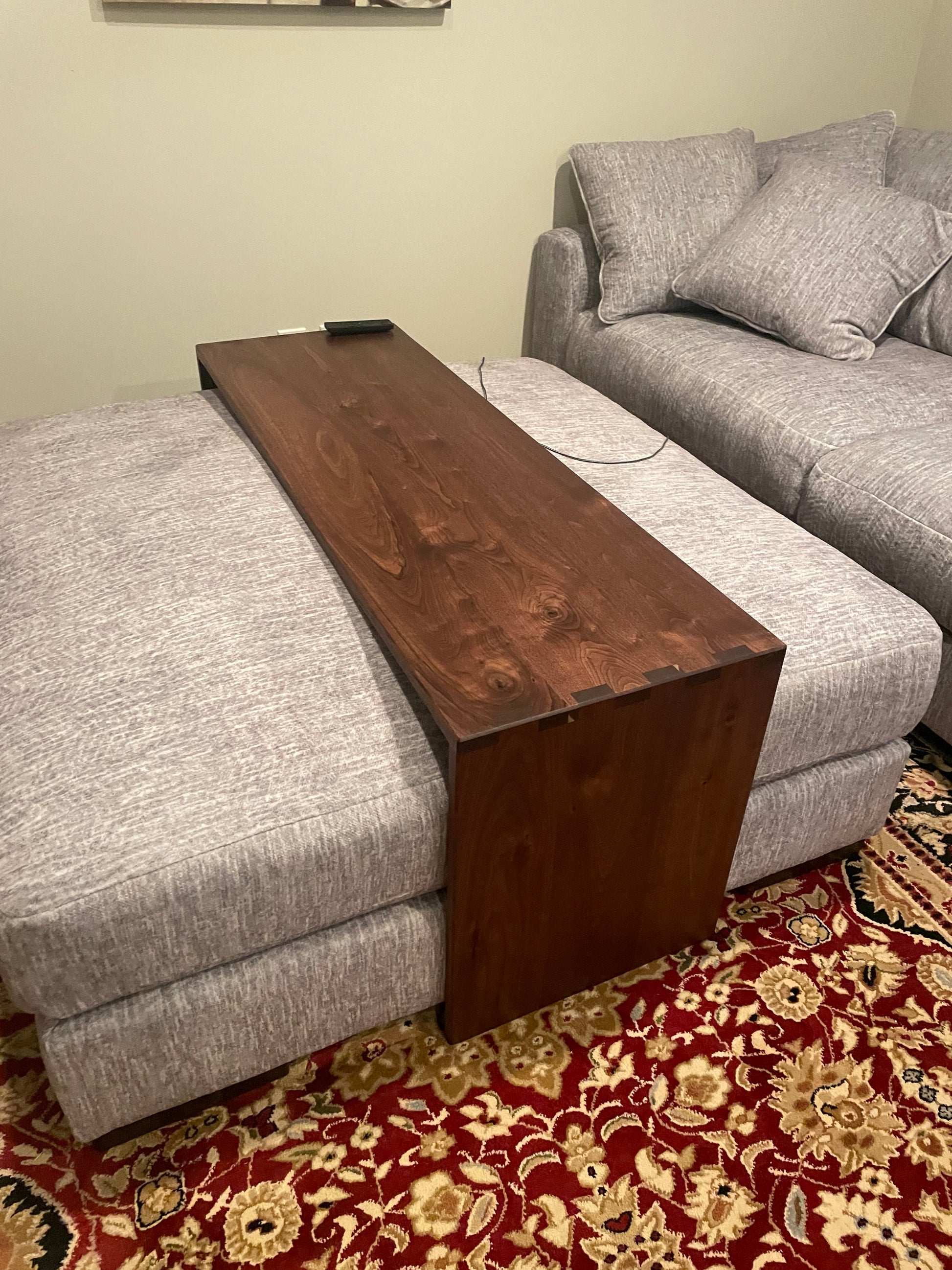 walnut ottoman table fitted over a grey fabric ottoman