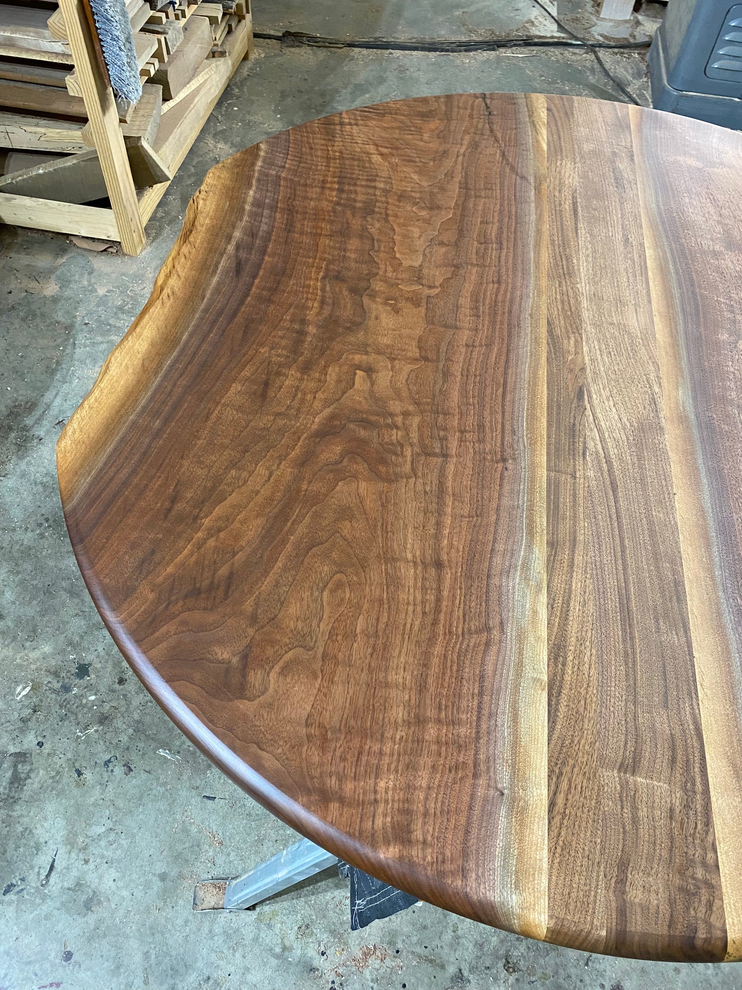one of a kind round dining table with natural walnut slab slab made in columbus ohio, tulip base, gloss black tulip base, walnut live edge, walnut slab, walnut dining table, hardwood dining table, handmade dining table in ohio, made in use, made in america, local business, small business, luxury furniture, bespoke furniture, walnut in the sun, figured walnut grain, beautiful rays curls 