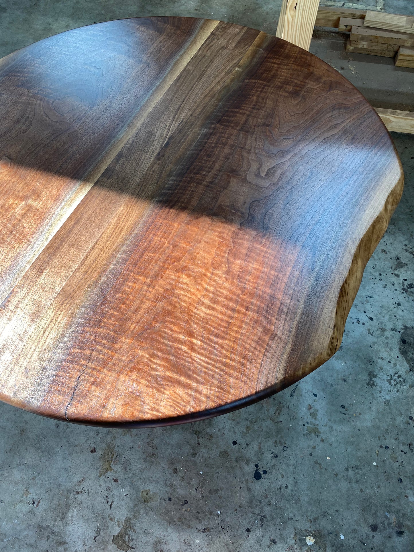 one of a kind round dining table with natural walnut slab slab made in columbus ohio, tulip base, gloss black tulip base, walnut live edge, walnut slab, walnut dining table, hardwood dining table, handmade dining table in ohio, made in use, made in america, local business, small business, luxury furniture, bespoke furniture, walnut in the sun, figured walnut grain, beautiful rays curls 