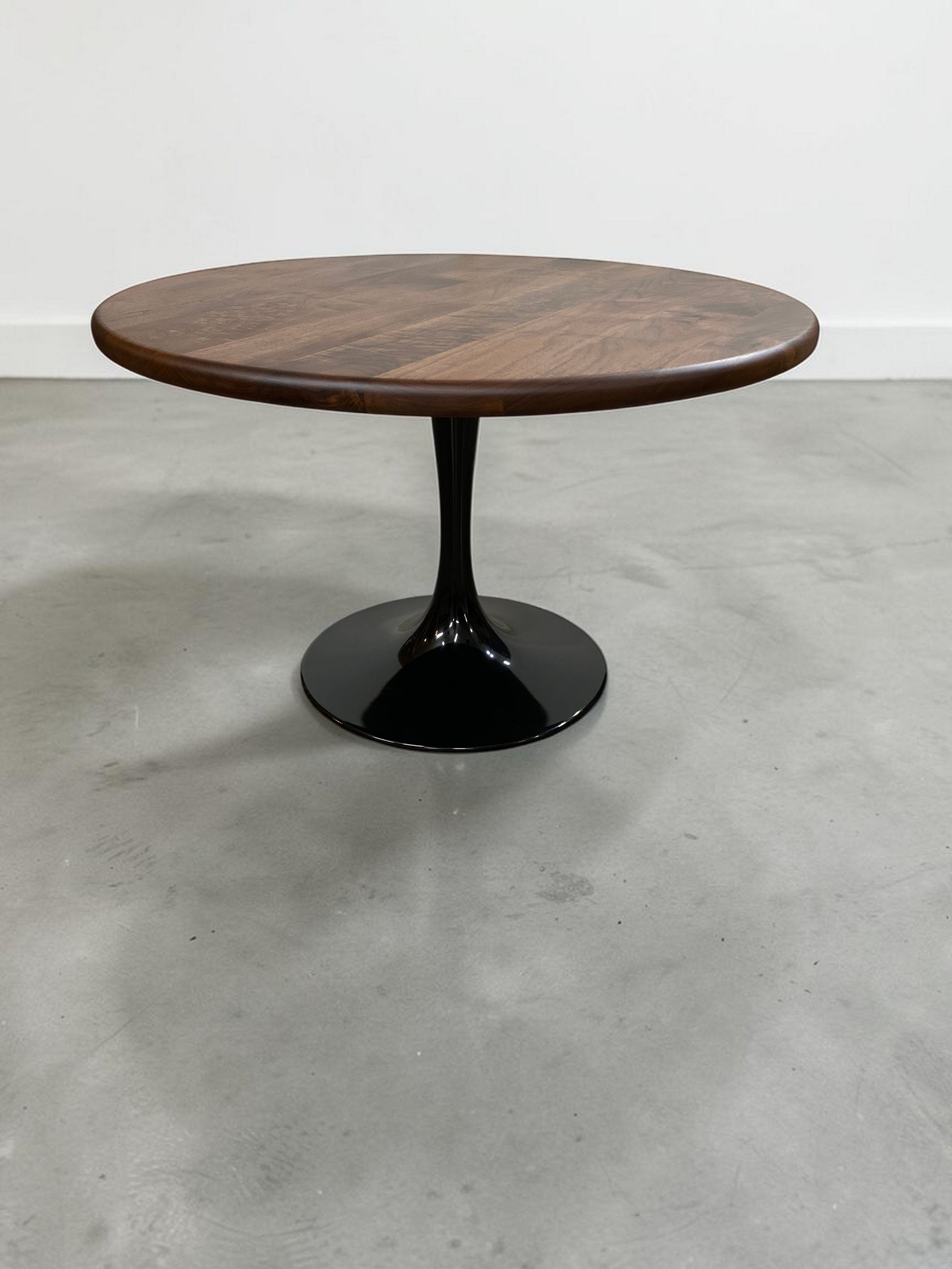 walnut wood round dining table with black metal tulip base, handmade in USA, made in america, made in ohio, solid walnut dining table with pedestal base